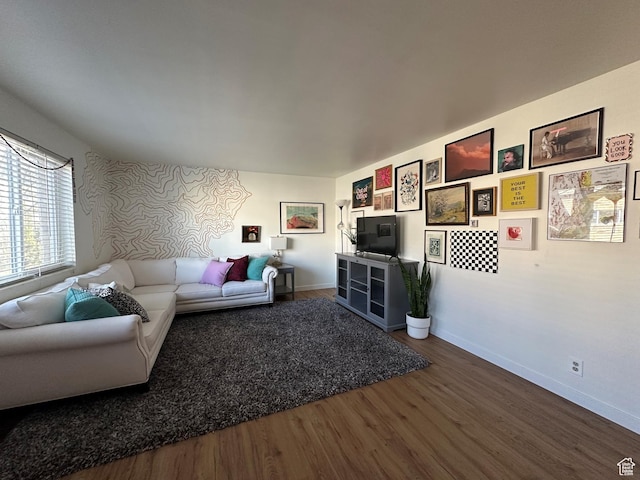 living area with baseboards and wood finished floors