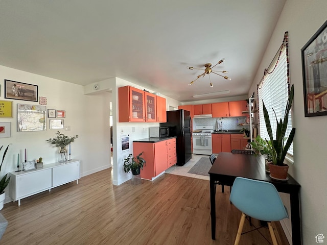 2220 E Murray Holladay Rd Unit 140, Holladay, UT 84117 - kitchen with black appliances, dark countertops, light wood-style floors, and backsplash
