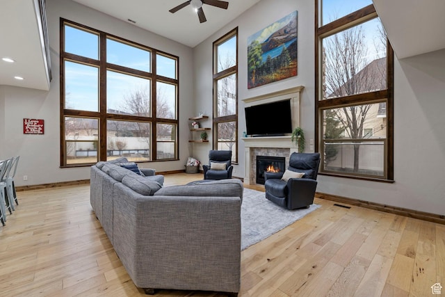 1532 W 3500 N, Pleasant Grove, UT 84062 - living area with a glass covered fireplace, light wood-style floors, ceiling fan, a high ceiling, and baseboards