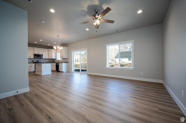 1357 N 450 W Unit 50, Brigham City, UT 84302 - unfurnished living room featuring ceiling fan with notable chandelier and hardwood / wood-style floors