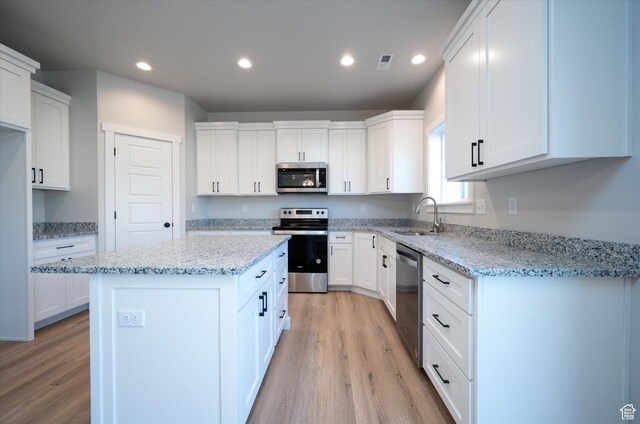 1357 N 450 W Unit 50, Brigham City, UT 84302 - kitchen featuring sink, white cabinetry, stainless steel appliances, light stone counters, and a kitchen island