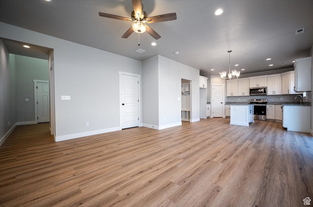 1357 N 450 W Unit 50, Brigham City, UT 84302 - kitchen featuring light hardwood / wood-style flooring, appliances with stainless steel finishes, white cabinetry, hanging light fixtures, and a center island