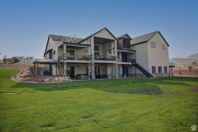 rear view of house with a gazebo, a balcony, a lawn, and cooling unit