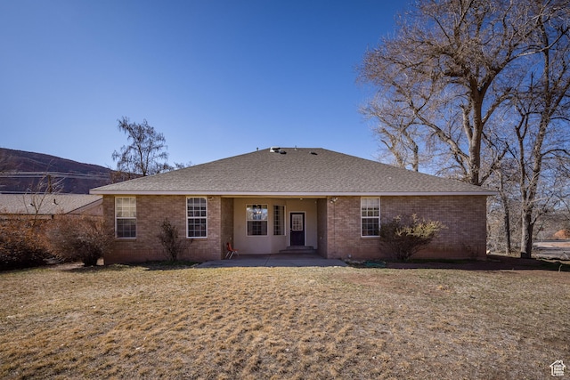 567 S 400 E, Moab, UT 84532 - rear view of house with brick siding, a shingled roof, a yard, and a patio area