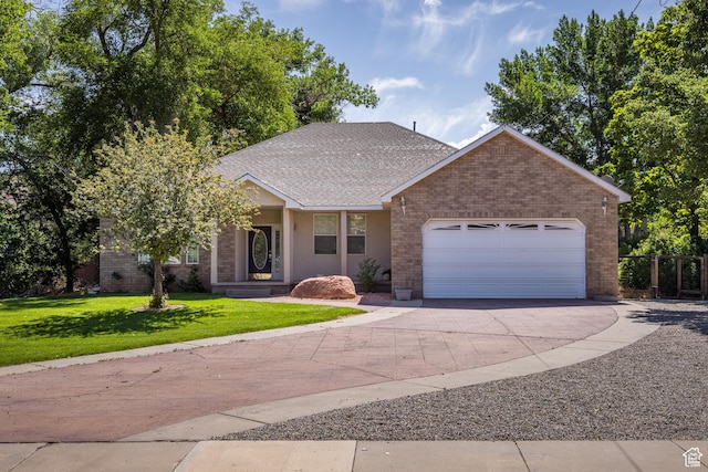 567 S 400 E, Moab, UT 84532 - view of front of home featuring driveway, an attached garage, a front yard, brick siding, and a shingled roof