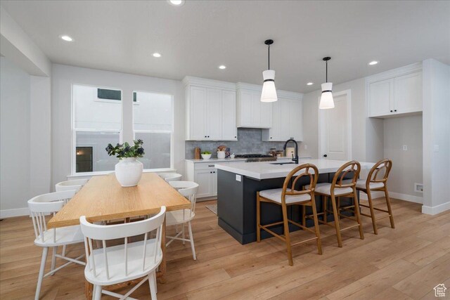 2998 N 1080 W, Lehi, UT 84043 - kitchen featuring decorative backsplash, an island with sink, white cabinets, and light wood-style flooring