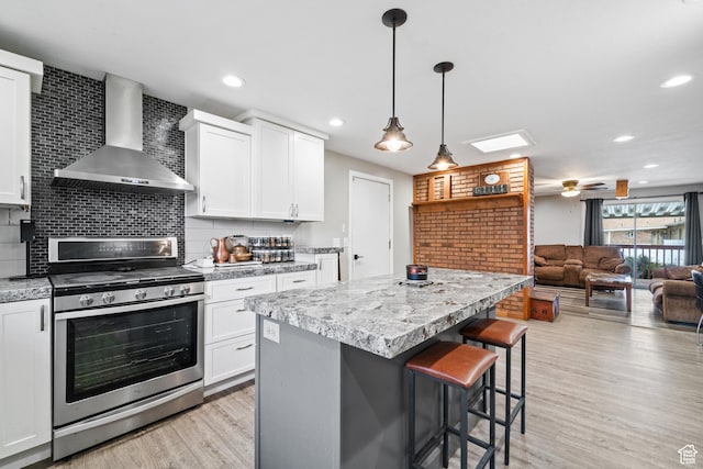 2283 E 7925 S, South Weber, UT 84405 - kitchen with decorative backsplash, wall chimney exhaust hood, stainless steel gas range oven, and a kitchen bar