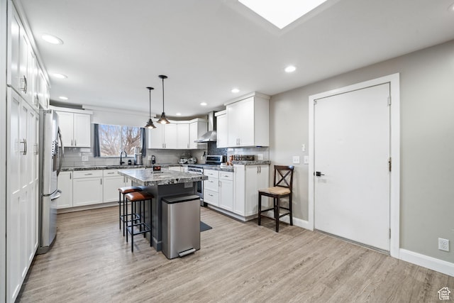2283 E 7925 S, South Weber, UT 84405 - kitchen with light wood-type flooring, a breakfast bar area, tasteful backsplash, and stainless steel appliances
