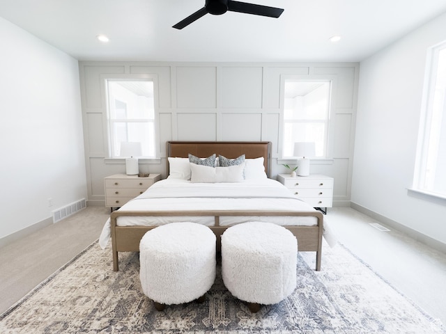 bedroom featuring a ceiling fan, visible vents, and multiple windows
