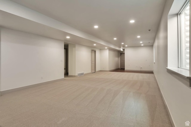 finished basement featuring recessed lighting, baseboards, visible vents, and light carpet