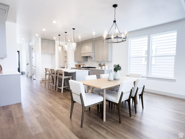 dining room featuring an inviting chandelier, recessed lighting, baseboards, and light wood-type flooring