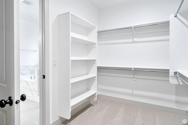 walk in closet with visible vents and carpet