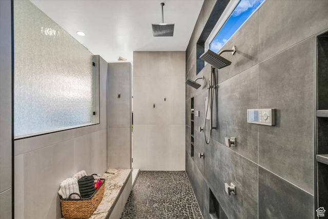 bathroom featuring a tile shower and tile walls