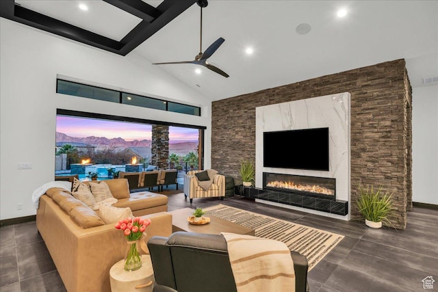 living room featuring beam ceiling, a premium fireplace, ceiling fan, and high vaulted ceiling