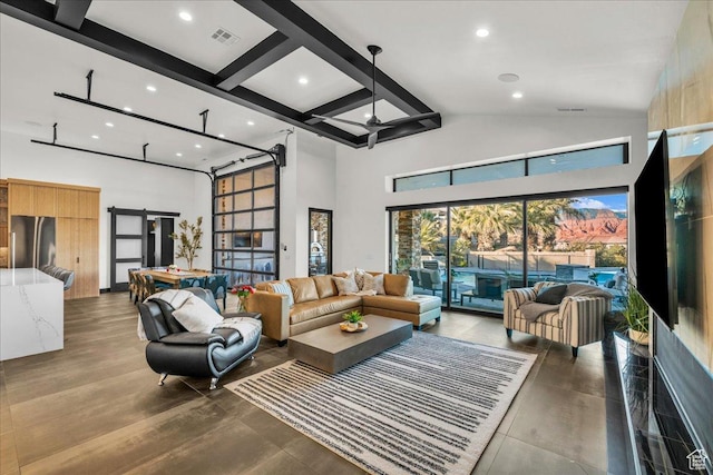 living room featuring hardwood / wood-style floors, high vaulted ceiling, beamed ceiling, ceiling fan, and a barn door