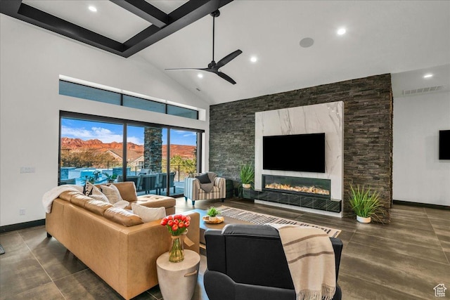 living room with beam ceiling, high vaulted ceiling, a premium fireplace, and ceiling fan