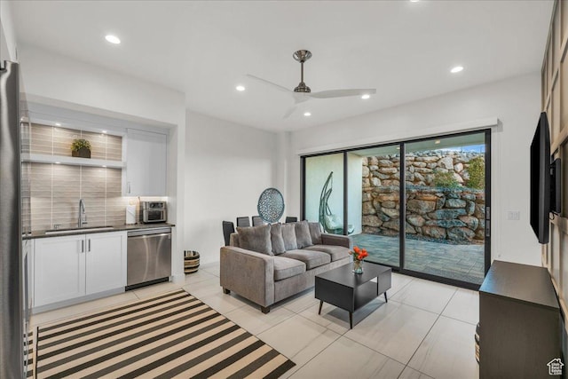 tiled living room featuring ceiling fan and sink