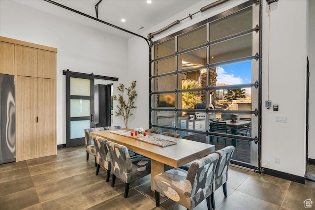 dining space featuring a high ceiling and a barn door
