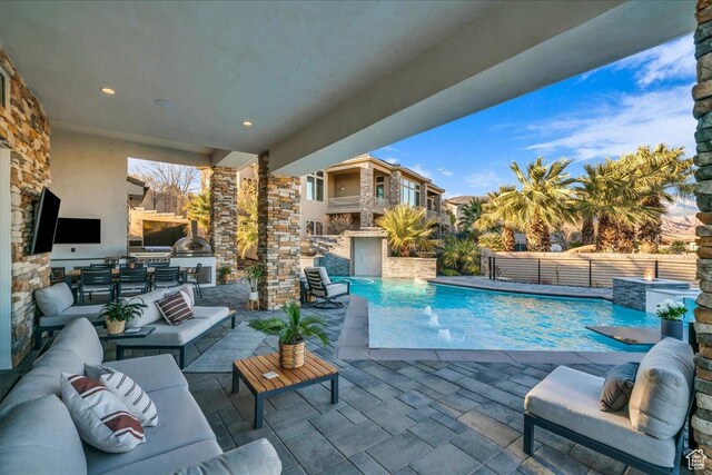 view of swimming pool with area for grilling, pool water feature, an outdoor hangout area, and a patio
