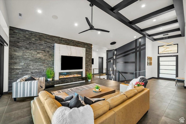 living room featuring beamed ceiling, a towering ceiling, dark tile patterned flooring, and ceiling fan
