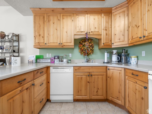 kitchen with white dishwasher, sink, a textured ceiling, and light tile patterned flooring