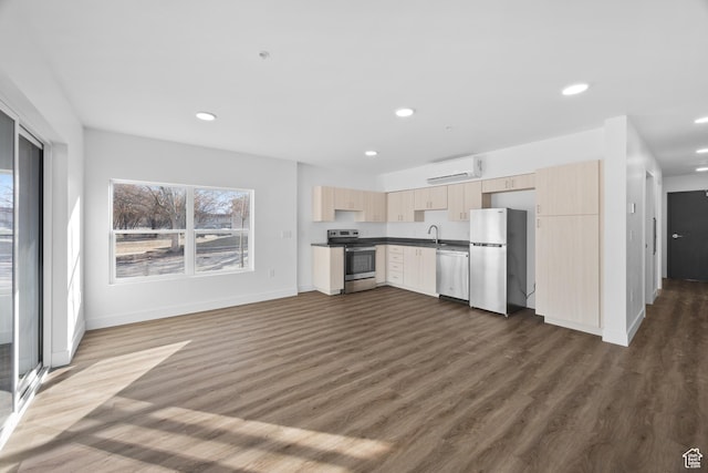 443 Kane Creek Blvd Unit A106, Moab, UT 84532 - kitchen with dark hardwood / wood-style flooring, appliances with stainless steel finishes, plenty of natural light, and a wall unit AC