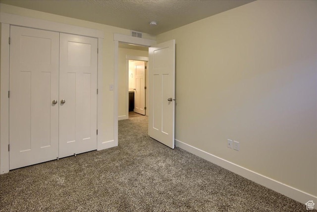 unfurnished bedroom with carpet floors, a closet, and a textured ceiling