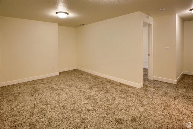 empty room with carpet and a textured ceiling