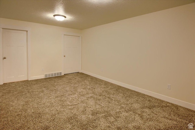 spare room with a textured ceiling and carpet