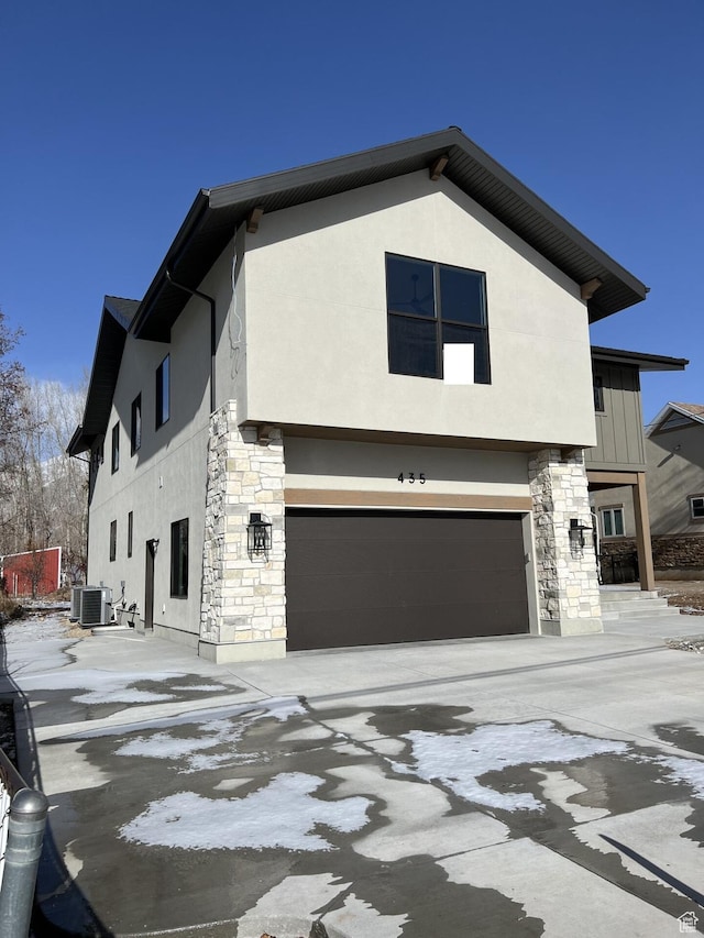 view of front facade with a garage and central AC unit