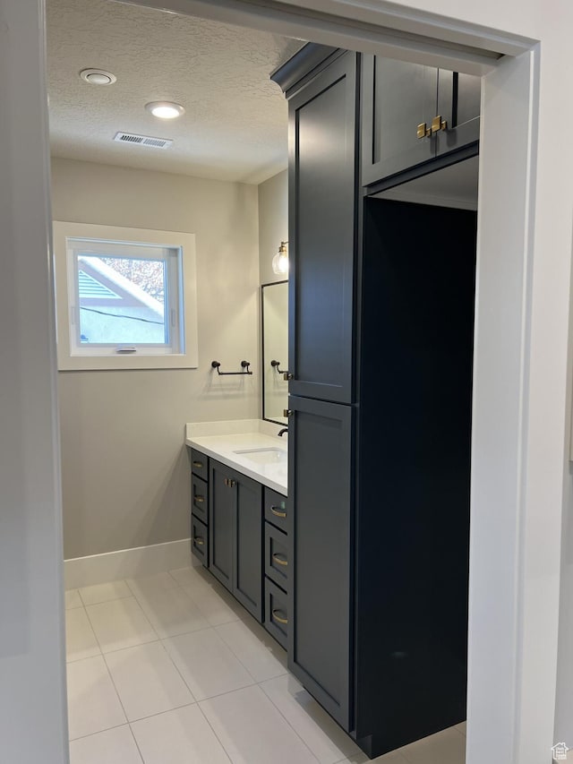 bathroom with vanity, tile patterned flooring, and a textured ceiling