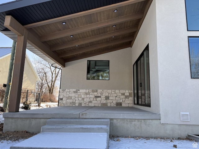 snow covered property entrance with a porch