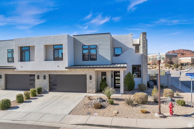 2227 N Double Eagle Ln, Washington, UT 84780 - view of front facade featuring stone siding, concrete driveway, a garage, a standing seam roof, and a metal roof