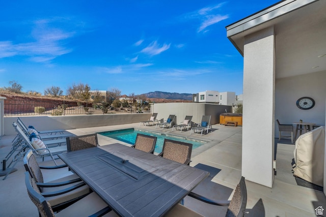 view of patio with a mountain view and a pool with hot tub