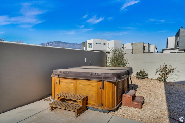 view of patio with a mountain view and a hot tub
