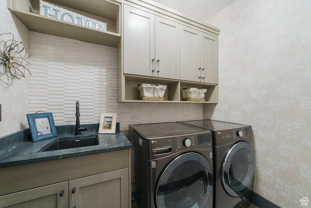 washroom featuring cabinets, separate washer and dryer, and sink