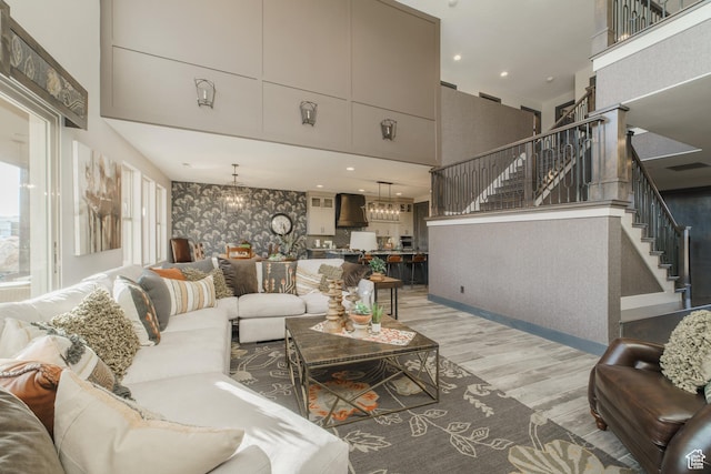 living room featuring a chandelier, a high ceiling, and light wood-type flooring