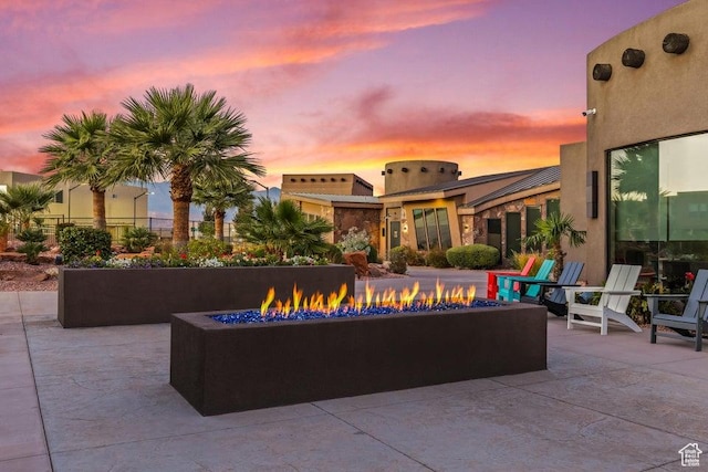 patio terrace at dusk featuring a fire pit