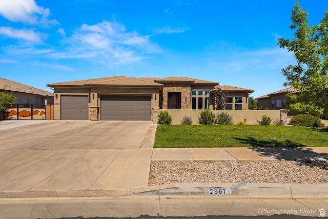 prairie-style house featuring a garage and a front lawn