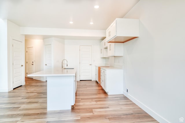241 E 100 N Unit 3, Moab, UT 84532 - kitchen with an island with sink, sink, white cabinets, and light wood-type flooring