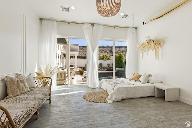 bedroom with a mountain view, visible vents, access to exterior, and an inviting chandelier