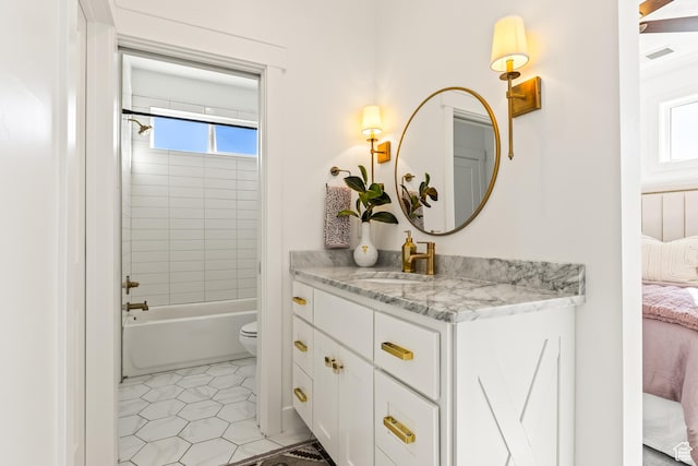 ensuite bathroom featuring toilet, a wealth of natural light, connected bathroom, and vanity
