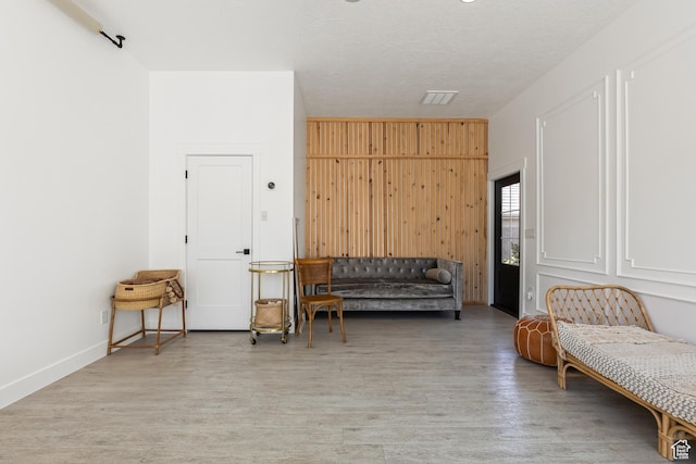 sitting room featuring wood walls and light wood-type flooring