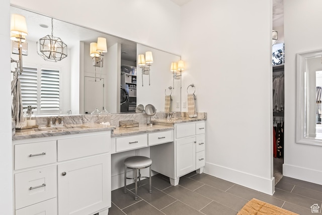 bathroom featuring a sink, double vanity, and plenty of natural light
