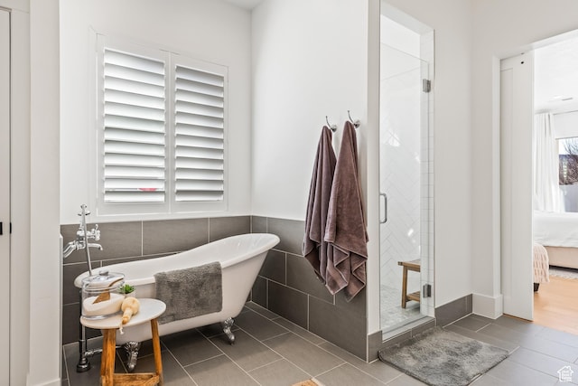 full bathroom featuring tile walls, a soaking tub, ensuite bath, tile patterned floors, and a stall shower