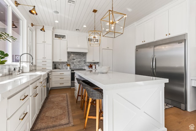 kitchen with dark wood-type flooring, a kitchen island, recessed lighting, wood ceiling, and stainless steel appliances