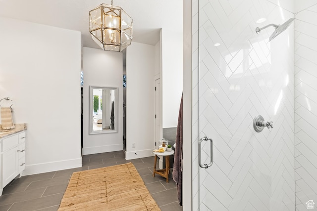 bathroom with a tile shower, an inviting chandelier, baseboards, and tile patterned flooring