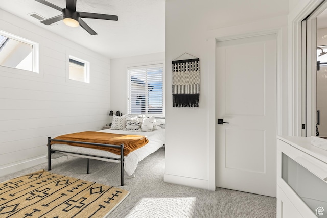 bedroom with light carpet, visible vents, and ceiling fan