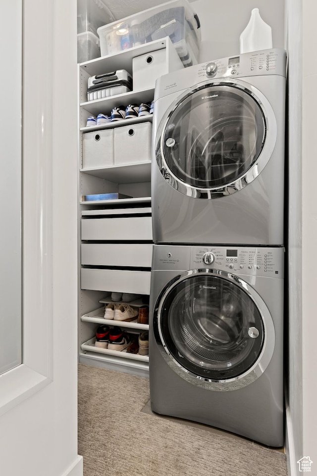 washroom featuring stacked washing maching and dryer and carpet
