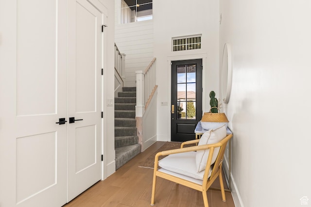entryway featuring stairway, baseboards, and wood finished floors